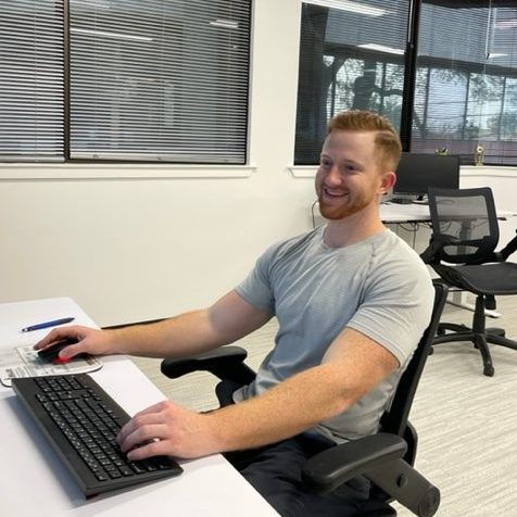 An employee of Lone Star Registered Agent in a gray shirt works at a computer in our office in Austin, TX.
